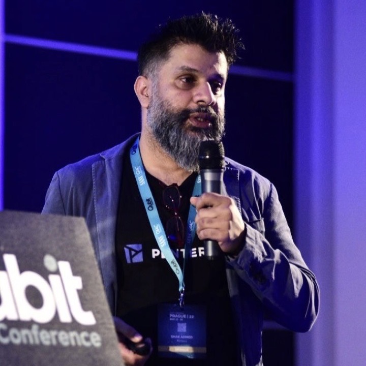 Shakel Ahmed speaking on stage at a conference